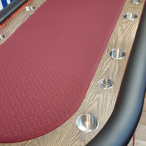 Classic red felt poker table with a rich oak rail